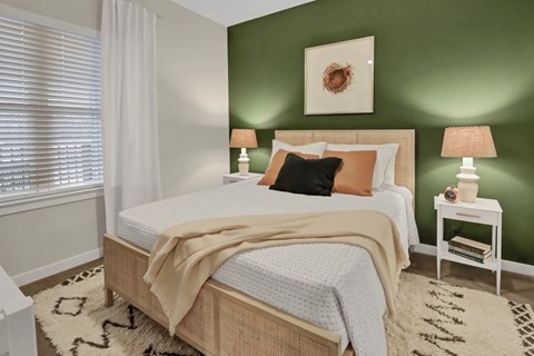 A bedroom with a bed, nightstand, and lamp.